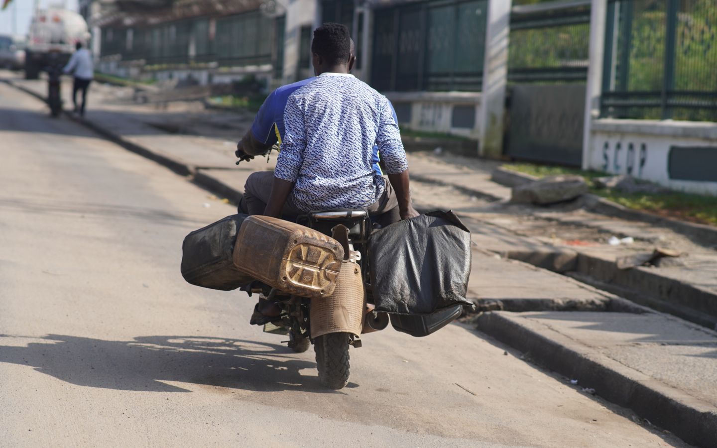 A man on a motorbike in Douala, loaded with jerrycans and bags